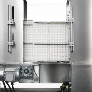 Close-up view of a tray washer cleaning seedling trays inside a stainless steel washing chamber